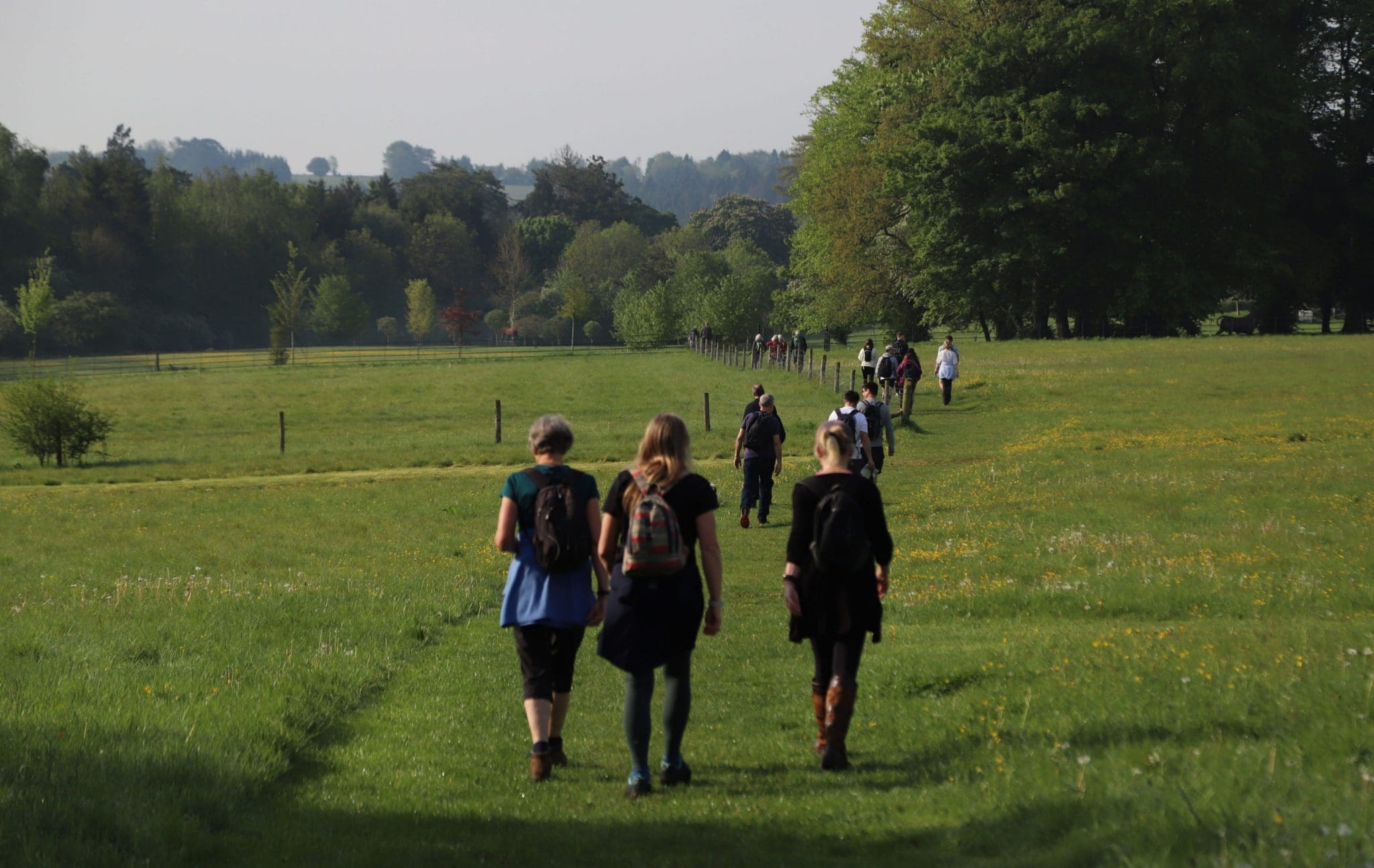 Walk The Churn 2026 A group of people walking in a field away from the cameraman